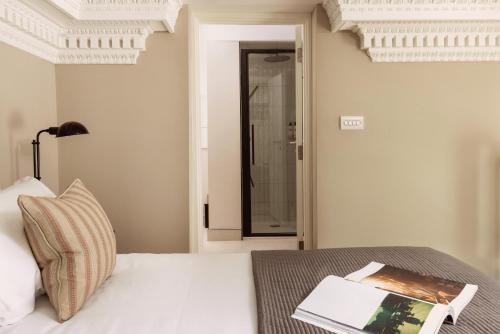 a bedroom with a bed with a book on a table at Native Hyde Park in London