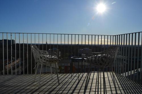 two chairs and a table on top of a balcony at Place Lund Apartments in Lund