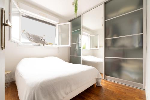 3 chambres lumineux proche gare et TNB في رين: غرفة نوم بسرير أبيض ونافذة