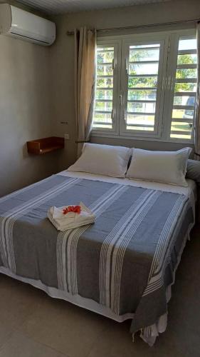a large bed in a room with a large window at Bungalow Le Petit Havre Pointois in Basse-Pointe