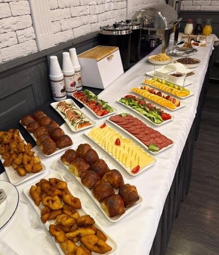 une table contenant de nombreux types de denrées alimentaires différents dans l'établissement SK Hotel, à Bishkek