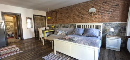 a living room with a couch and a brick wall at Staszica Starówka in Olsztyn