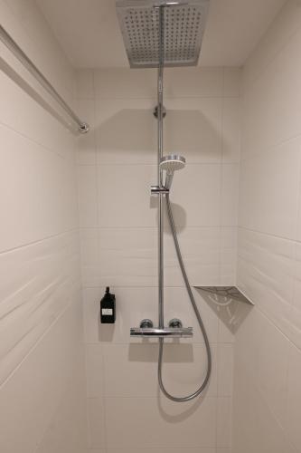 a shower in a white tiled bathroom at Le Navire-Plage du Nau-Parc-Résidence calme-Garage in Le Pouliguen