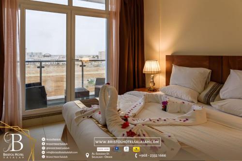 a hotel room with a large bed with a window at Bristol Hotel Long Stayer in Salalah