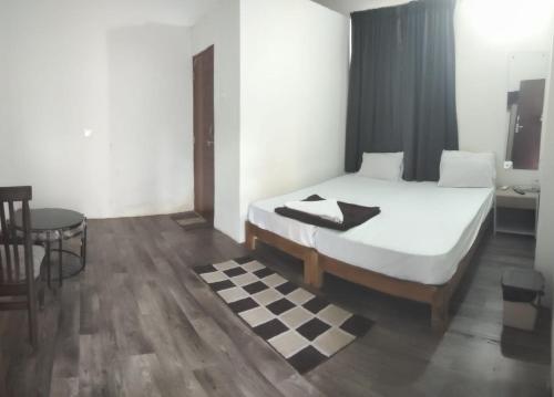 een slaapkamer met een bed en een geruite vloer bij HOTEL SUDHAKAR ROOMS AND DORMITORYs in Panaji