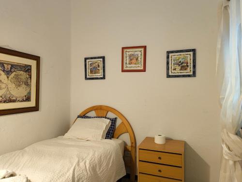 a bedroom with a bed and a nightstand with a bed and a picture at Buenas vistas y privacidad, tranquila y fresca villa en el bosque de Valencia con una magnífica piscina de 80m2 in Lliria
