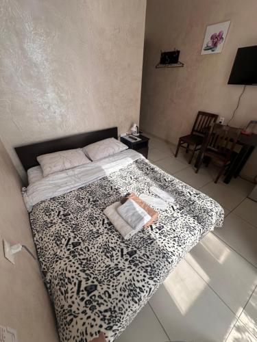 een slaapkamer met een bed met een luipaardprint deken bij Glori in Tbilisi City