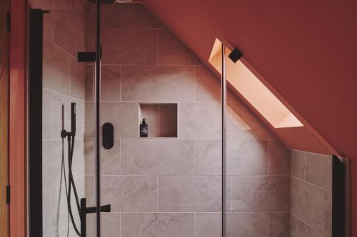 a bathroom with a shower in a attic at Hay Barn in Trefeglwys
