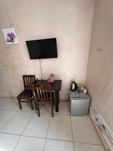 een kamer met een tafel en een televisie aan de muur bij Glori in Tbilisi City