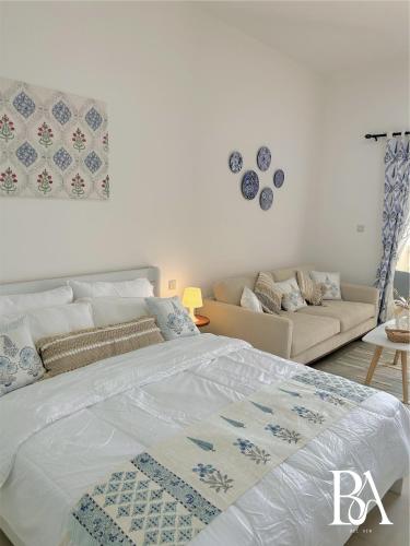 um quarto com uma cama e um sofá em Bel Air -- Sea View Studio em Ras al-Khaimah
