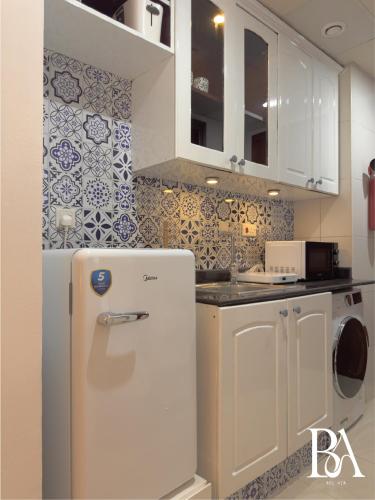 a kitchen with a white refrigerator in a room at Bel Air -- Sea View Studio in Ras al Khaimah