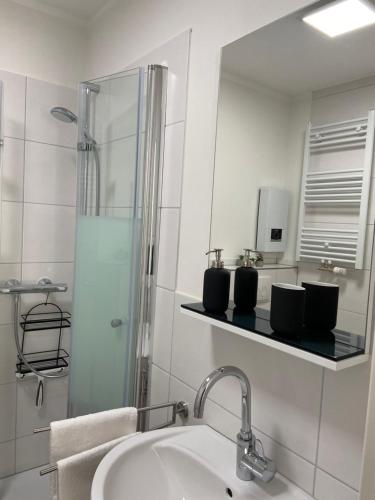 a white bathroom with a sink and a mirror at FeWo Seetraum in Diemelsee