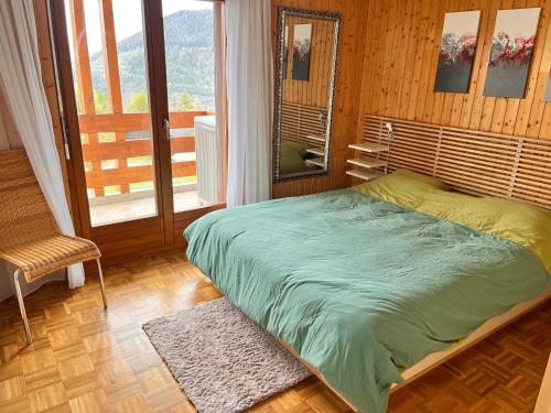 Un dormitorio con una cama y una ventana grande. en Spacieux appartment 4 Vallées La Tzoumaz Verbier, en Riddes