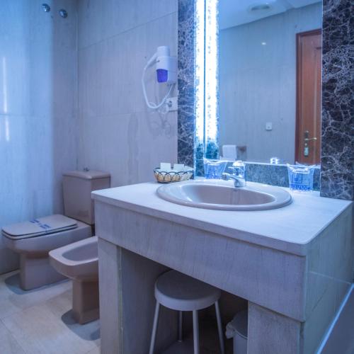 a bathroom with a sink and a toilet at Pousada de Portomarín in Portomarin