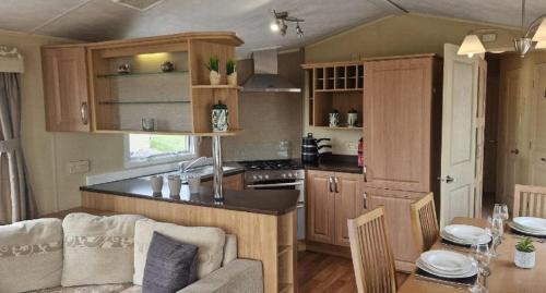 Una cocina y una sala de estar con un sofá y una mesa. en Lovely 8 Berth Caravan With Large Decking At Withernsea Sands Ref 79005Kg, en Waxholme