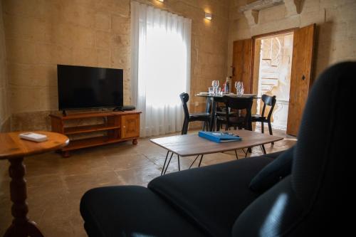 un soggiorno con un divano, una TV e un tavolo di Ta' Keninu a Sannat