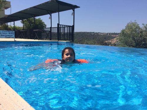 a young girl is swimming in a swimming pool at Hotel Sema in Patara