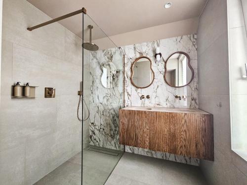 a bathroom with a sink and two mirrors at Number 9 holiday apartments in Middelburg