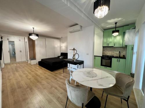 eine Küche und ein Wohnzimmer mit Tisch und Stühlen in der Unterkunft Studio One Cassas Residence in Craiova