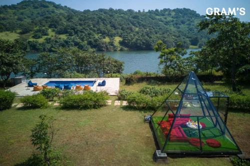 a backyard with a swimming pool and a playground at Gram's at Shivom, Pawna Lake in Lonavala