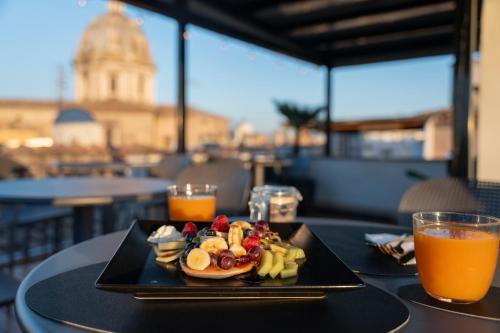 ローマにあるCampo de' Fiori 34のオレンジジュースを添えたテーブルの上に並べた朝食用の食品