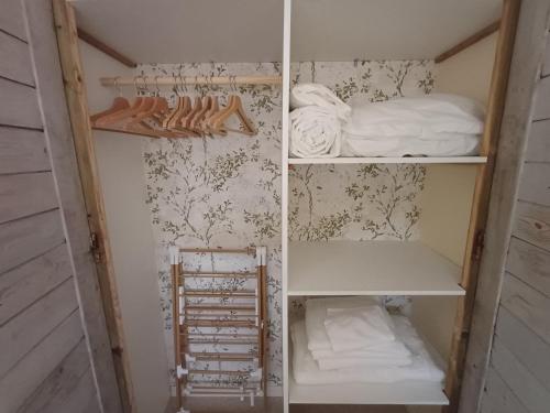 a closet with shelves and a bed in it at Douce Parenthèse au bord de l'eau in La Celle-sous-Gouzon