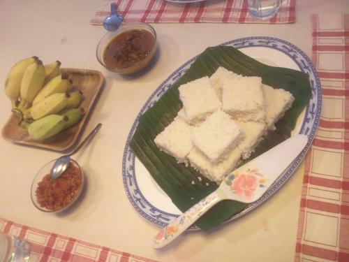 Una mesa con un plato de pastel y plátanos. en Mervins & Indus Residence, en Nugegoda