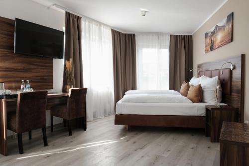 a bedroom with a bed and a desk with a computer at sQuare Hotel in Frankfurt/Main