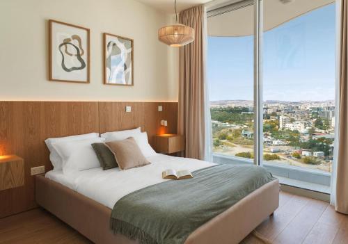 une chambre avec un grand lit et une grande fenêtre dans l'établissement Suite 1003 at Althea Residence, à Scala