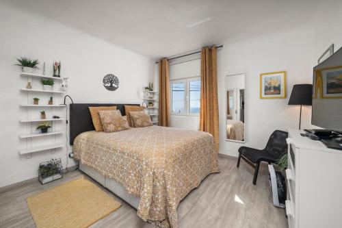 a bedroom with a bed and a window and a television at Casa Gudrun in Praia do Carvoeiro