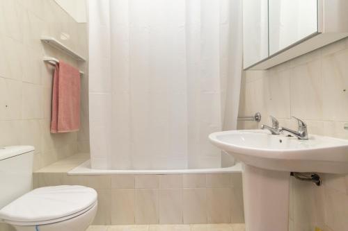 a bathroom with a sink and a toilet and a tub at Coast 2 Bedroom Apart Setúbal 45 min from Lisbon in Setúbal
