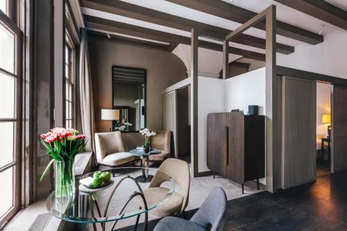 a living room with a glass table and chairs at The Dylan Amsterdam - The Leading Hotels of the World in Amsterdam