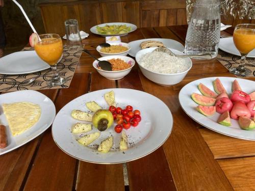 einen Holztisch mit Teller mit Lebensmitteln und Obst in der Unterkunft THE HIDEOUT KURUNEGALA in Kurunegala