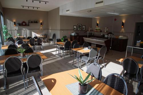 a dining room with tables and chairs and a piano at Trudvang Apartment Hotel in Rena