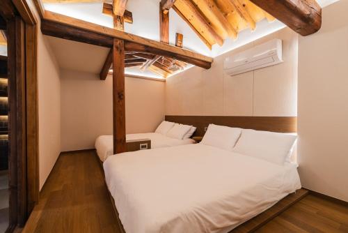 two beds in a room with wooden beams at Luxury Hanok MOOD-AM in Seoul
