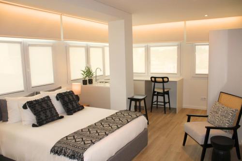 a bedroom with a bed and a table and chairs at ma-la studios Guimarães in Guimarães