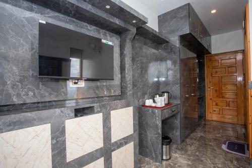 a bathroom with a television on the wall at Tara Van in Dharamshala