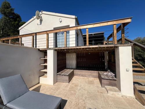 a house with a balcony with a chair on a patio at Petite villa cocooning in Sisco