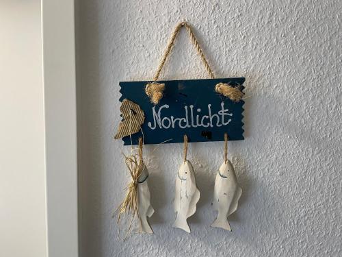 a group of three fish hanging on a wall at Nordlicht im Haus Kaya, Hafenstraße in Wyk auf Föhr