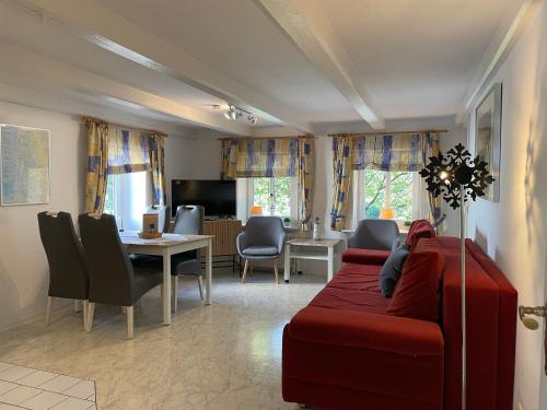 a living room with a red couch and a dining room at Nordlicht im Haus Kaya, Hafenstraße in Wyk auf Föhr