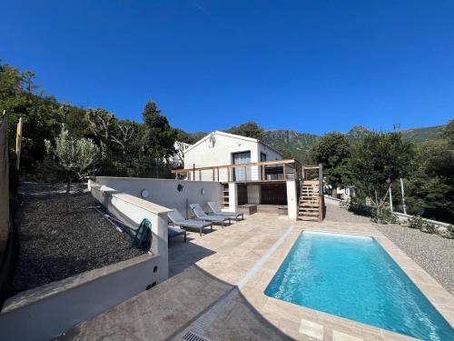 a backyard with a swimming pool and a house at Petite villa cocooning in Sisco