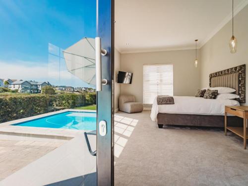 1 dormitorio con cama y piscina en Moorlands Manor, en George