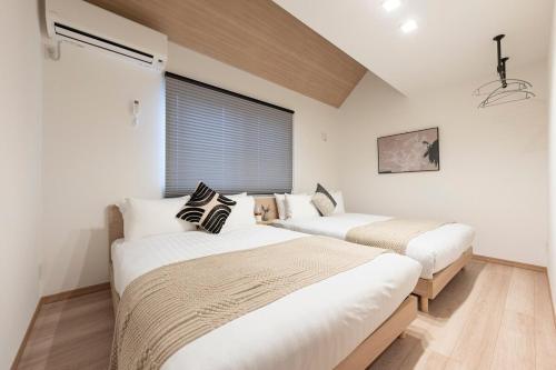 Dos camas en una habitación con ventana. en 和船 wafune, en Tokio