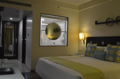 a bedroom with a large bed and a mirror at Fortune Inn Sree Kanya, Visakhapatnam - Member ITC's Hotel Group in Visakhapatnam