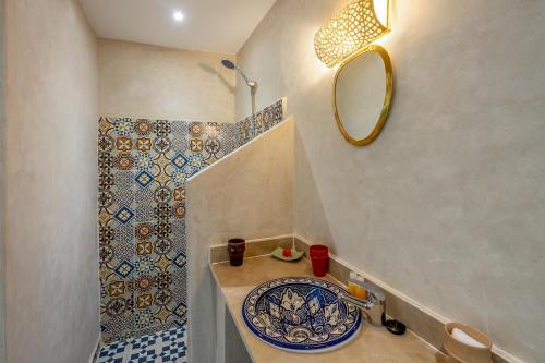 マラケシュにあるRiad Jabador De Marrakechの洗面台と鏡のあるバスルーム