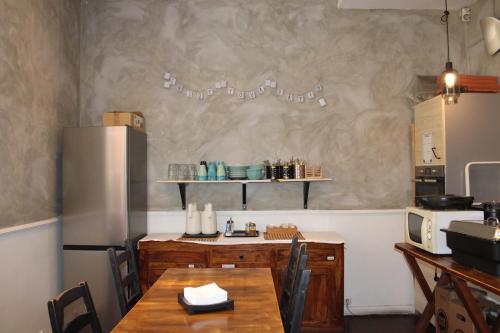a kitchen with a wooden table and a refrigerator at Rossio Hostel in Lisbon