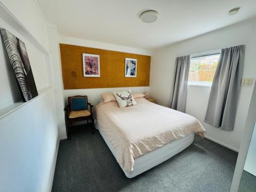 a small bedroom with a bed and a window at Delight at Golf in Auckland