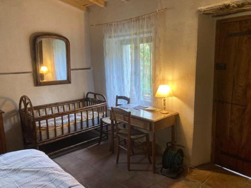 a bedroom with a bed and a desk and a crib at Un Mazet en famille dans le jardin in Saint-Hippolyte-du-Fort