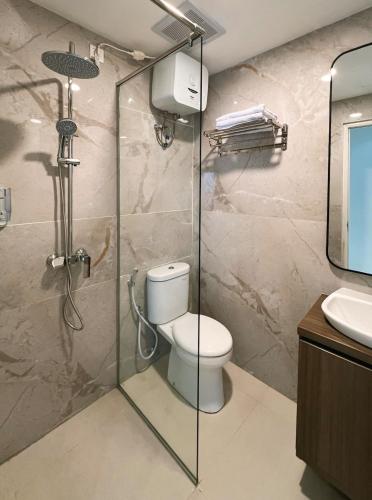 a bathroom with a shower with a toilet and a sink at Luxury 3BR Podomoro Suite Medan City View NEW! in Medan