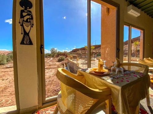 a dining room table with a view of the desert at Dar Bikouch in Aït Ben Haddou